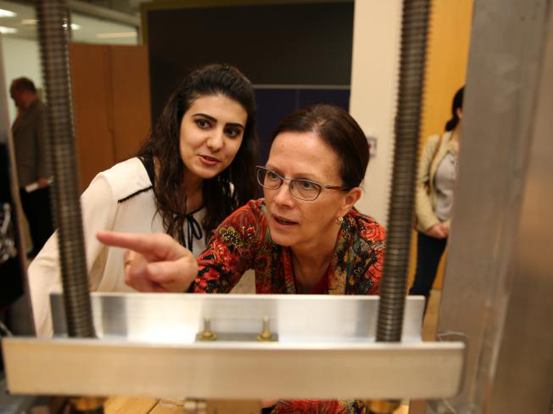A female professor and a female student examine engineering equipment